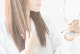 自分の髪を鏡で見る女性