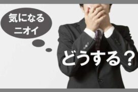 鼻と口を手で覆う男性