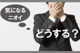 鼻と口を手で覆う男性